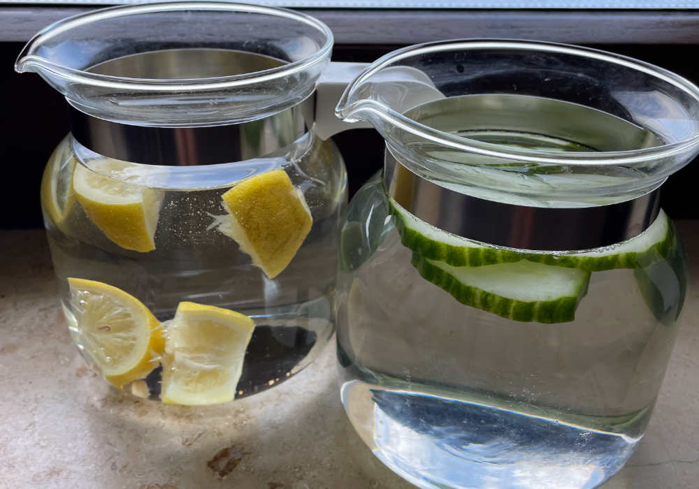 zwei Wasserkannen mit Zitronen- und Gurkenwasser, um Hitze zu überstehen